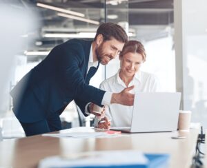 Happy employee showing presentation to mature female boss for discussing online project